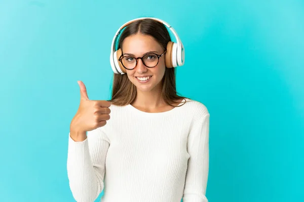 Jovem Mulher Sobre Fundo Azul Isolado Ouvir Música Com Polegar — Fotografia de Stock