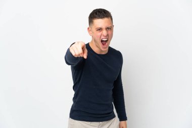 Beyaz arka planda izole edilmiş genç beyaz adam hayal kırıklığına uğramış ve ön tarafı işaret ediyor.