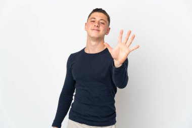 Beyaz arka planda izole edilmiş genç beyaz adam parmaklarıyla beşi sayıyor.