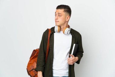 Beyaz arka planda izole edilmiş genç beyaz öğrenci yan tarafa bakıyor.
