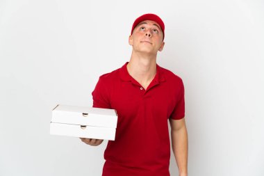İş üniformalı bir pizzacı beyaz arka planda izole edilmiş pizza kutuları alıyor ve...