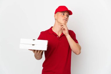 İş üniformalı bir pizzacı beyaz arka planda izole edilmiş pizza kutularını topluyor.