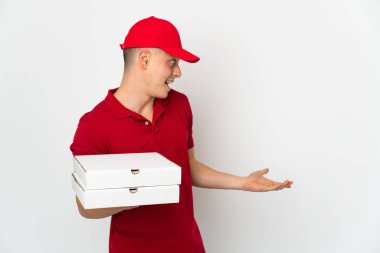 İş üniformalı bir pizzacı beyaz arka planda izole edilmiş pizza kutularını topluyor.