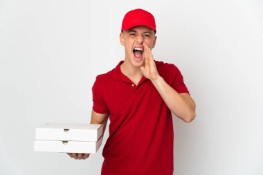 İş üniformalı bir pizzacı beyaz arka planda izole edilmiş pizza kutularını topluyor ve ağzı açık bağırıyor.
