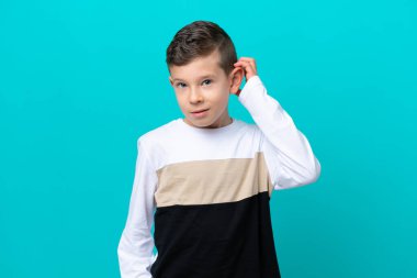 Küçük çocuk mavi arka planda izole edilmiş. Şüpheleri var.