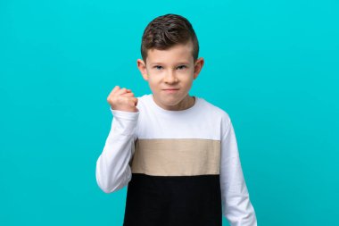 Küçük çocuk mutsuz bir ifadeyle mavi arka planda izole edilmiş.