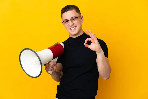 Jonge Blanke Man Geïsoleerd Gele Achtergrond Met Een Megafoon Vertonen — Stockfoto