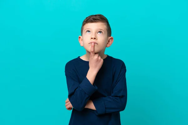Kleiner Junge Isoliert Auf Blauem Hintergrund Mit Zweifeln Beim Nachschauen — Stockfoto
