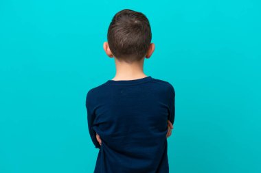 Küçük çocuk mavi arka planda izole edilmiş.