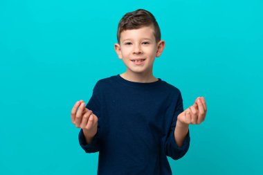 Küçük çocuk mavi arka planda izole edilmiş para hareketi yapıyor.