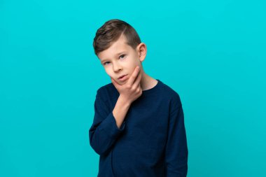 Küçük çocuk mavi arka planda izole edilmiş. Şüpheleri var.