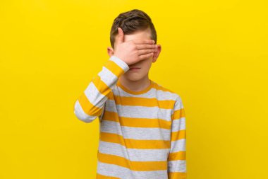Sarı arka planda izole edilmiş küçük beyaz çocuk gözleri elleriyle kapatıyor. Bir şey görmek istemiyorum.