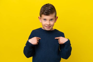 Küçük beyaz çocuk sarı arka planda izole edilmiş, şaşırmış bir yüz ifadesi var.