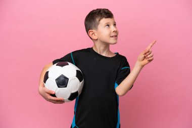 Pembe arka planda izole edilmiş beyaz futbolcu çocuk harika bir fikre işaret ediyor.