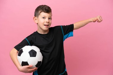 Kafkas futbolcu çocuk pembe arka planda izole edilmiş bir şekilde baş parmak hareketi yapıyor.