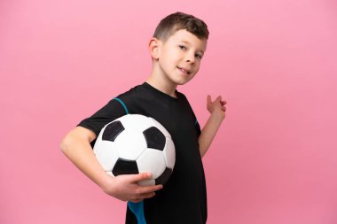 Pembe arka planda izole edilmiş beyaz futbolcu çocuk.
