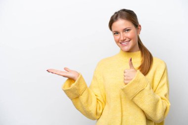 Beyaz arka planda izole edilmiş genç beyaz bir kadın bir ilan vermek ve onaylamak için avucunun içinde hayali bir mekan tutuyor.