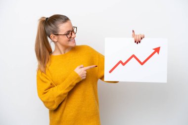 Beyaz arka planda izole edilmiş genç beyaz bir kadın elinde büyüyen bir istatistik okunun sembolü olan bir tabela tutuyor ve onu işaret ediyor.