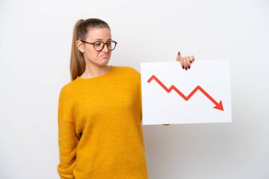 Beyaz arka planda izole edilmiş genç beyaz bir kadın elinde azalan bir istatistik okuyla hüzünlü bir ifadeyle bir işaret tutuyor.