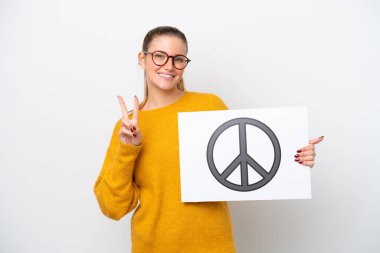 Beyaz arka planda izole edilmiş beyaz bir kadın barış sembollü bir levha tutuyor ve zaferi kutluyor.