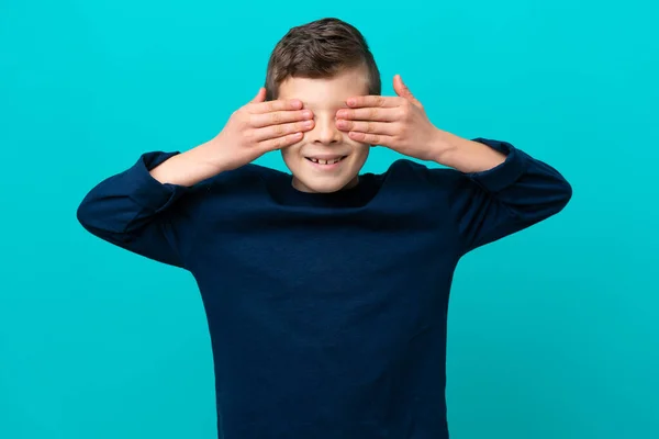 Malý Chlapec Izolovaný Modrém Pozadí Zakrývá Oči Rukama Usmívá — Stock fotografie