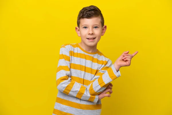 Mały Biały Chłopiec Odizolowany Żółtym Tle Szczęśliwy Wskazując Górę — Zdjęcie stockowe