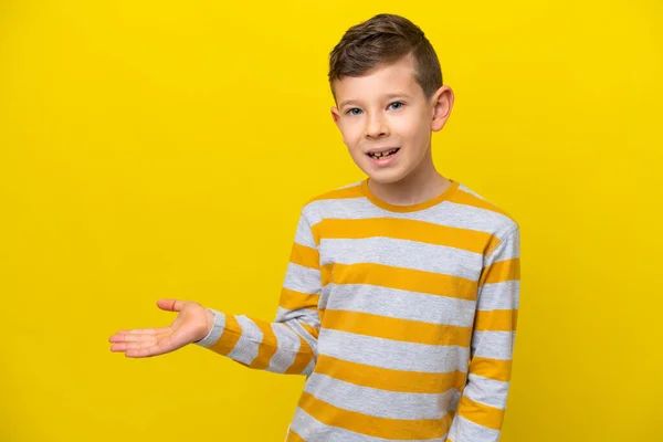 Pequeño Chico Caucásico Aislado Sobre Fondo Amarillo Presentando Una Idea —  Fotos de Stock