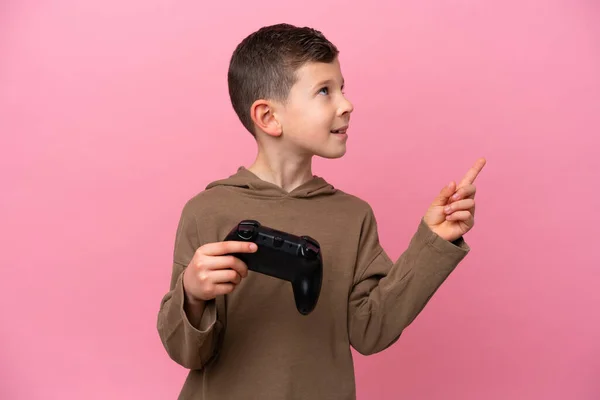 Маленький Белый Мальчик Играет Контроллером Видеоигры Изолированы Розовом Фоне Указывая — стоковое фото