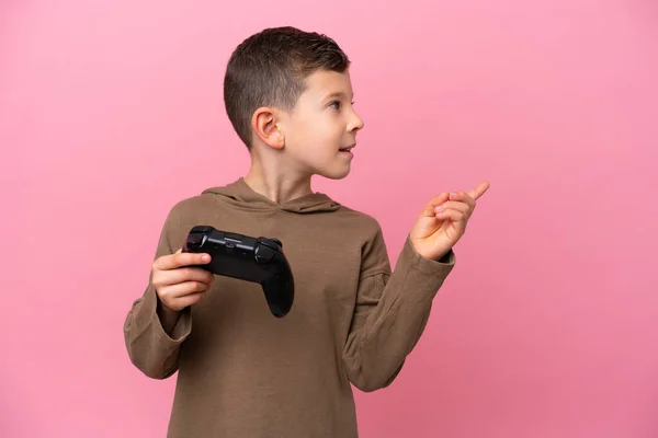 Маленький Кавказский Мальчик Играет Контроллером Видеоигры Изолированы Розовом Фоне Намереваясь — стоковое фото