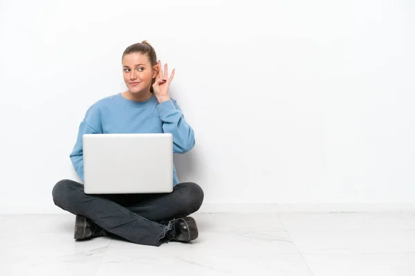 Junge Frau Mit Laptop Sitzt Auf Dem Boden Und Hört — Stockfoto