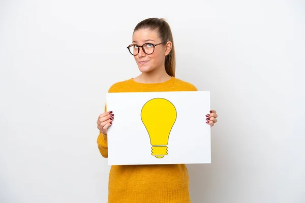 Young Caucasian Woman Isolated White Background Holding Placard Bulb Icon — Stock Photo, Image