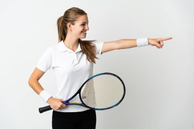 Beyaz arka planda tenis oynayan beyaz tenli genç kadın.