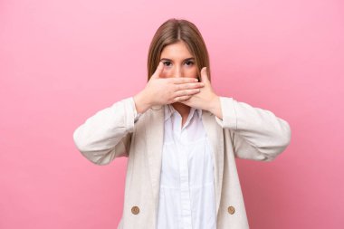 Pembe fırında izole edilmiş genç beyaz kadın elleriyle ağzını kapatıyor.