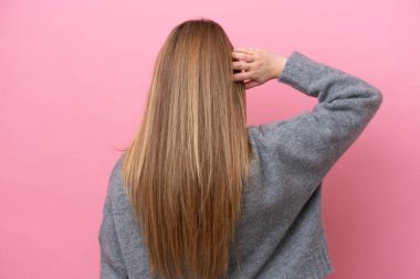 Kafkasyalı genç bir kadın arka plandaki pembe fırında izole edilmiş ve düşünüyor.