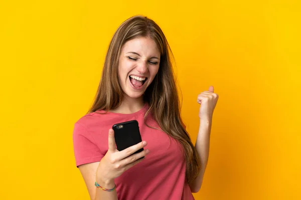 Mujer Joven Usando Teléfono Móvil Aislado Sobre Fondo Amarillo Celebrando —  Fotos de Stock
