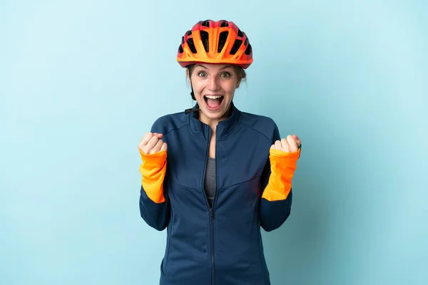 Genç Bisikletçi Kadın Mavi Arka Planda Tek Başına Zaferi Kutluyor — Stok fotoğraf