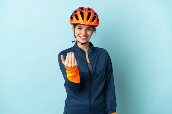 Молодая Женщина Велосипедистка Изолированная Синем Фоне Приглашает Прийти Рукой Рад — стоковое фото
