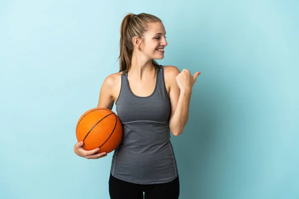 Young Woman Playing Basketball Isolated Blue Background Pointing Side Present — Stock Photo, Image
