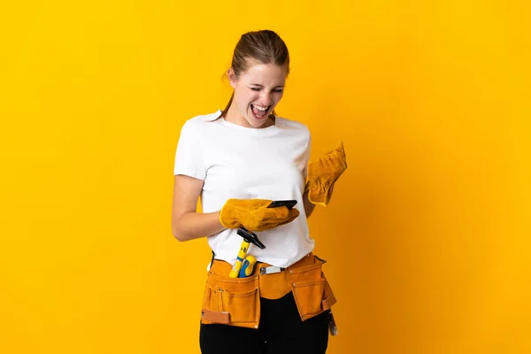 Junge Elektrikerin Isoliert Auf Gelbem Hintergrund Mit Handy Siegerposition — Stockfoto
