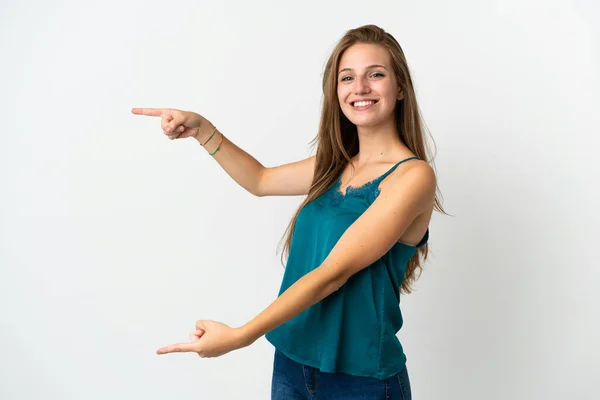 孤立した背景を持つ若い白人女性が指を横に向け 製品を提示する — ストック写真