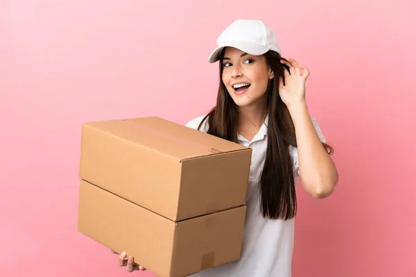 Delivery Girl Isolated Pink Wall Listening Something Putting Hand Ear — Stock Photo, Image