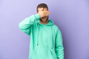 Mor arka planda, gözleri elleriyle kapatan yakışıklı beyaz bir adam. Bir şey görmek istemiyorum.