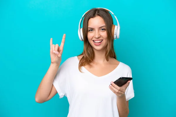 Jonge Kaukasische Vrouw Geïsoleerd Blauwe Achtergrond Luisteren Muziek Met Een — Stockfoto
