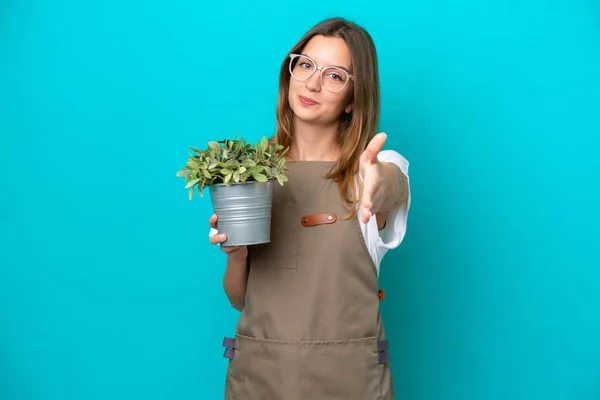 Jonge Kaukasische Tuinman Vrouw Houden Van Een Plant Geïsoleerd Blauwe — Stockfoto