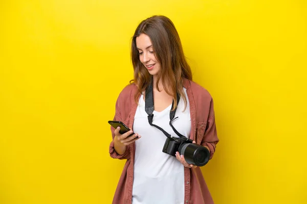 Young Photographer Caucasian Woman Isolated Yellow Background Sending Message Mobile — Stock Photo, Image
