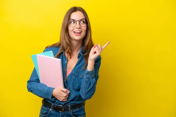 指を持ち上げながら解決策を実現しようと黄色の背景に隔離された若い学生の白人女性 — ストック写真