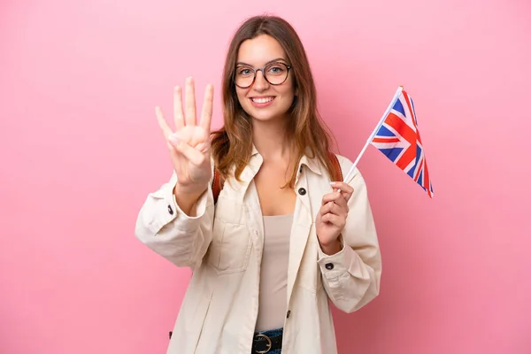 年轻的女学生高举一面英国国旗 背景为粉色 高兴极了 手指头数着四 — 图库照片