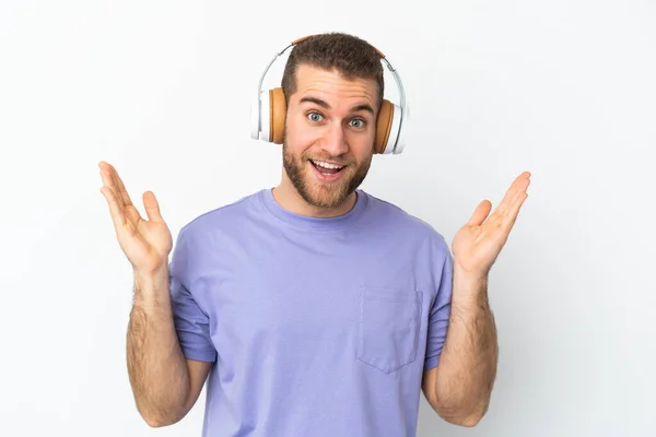 Jonge Knappe Blanke Man Geïsoleerd Witte Achtergrond Verrast Luisteren Muziek — Stockfoto