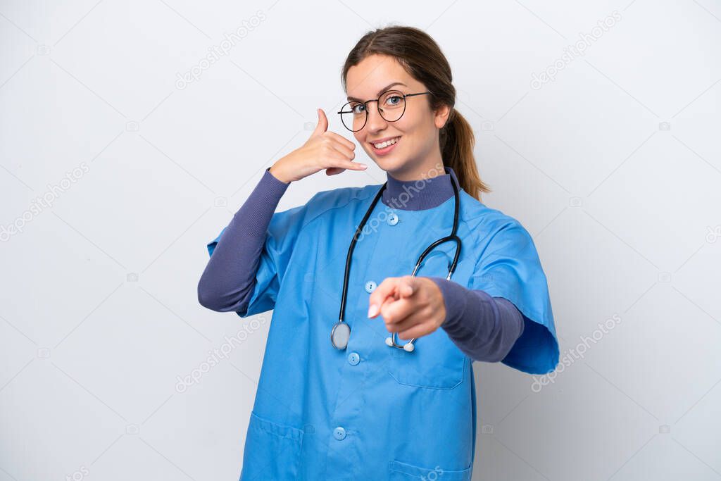 Young caucasian nurse woman isolated on white background making phone gesture and pointing front