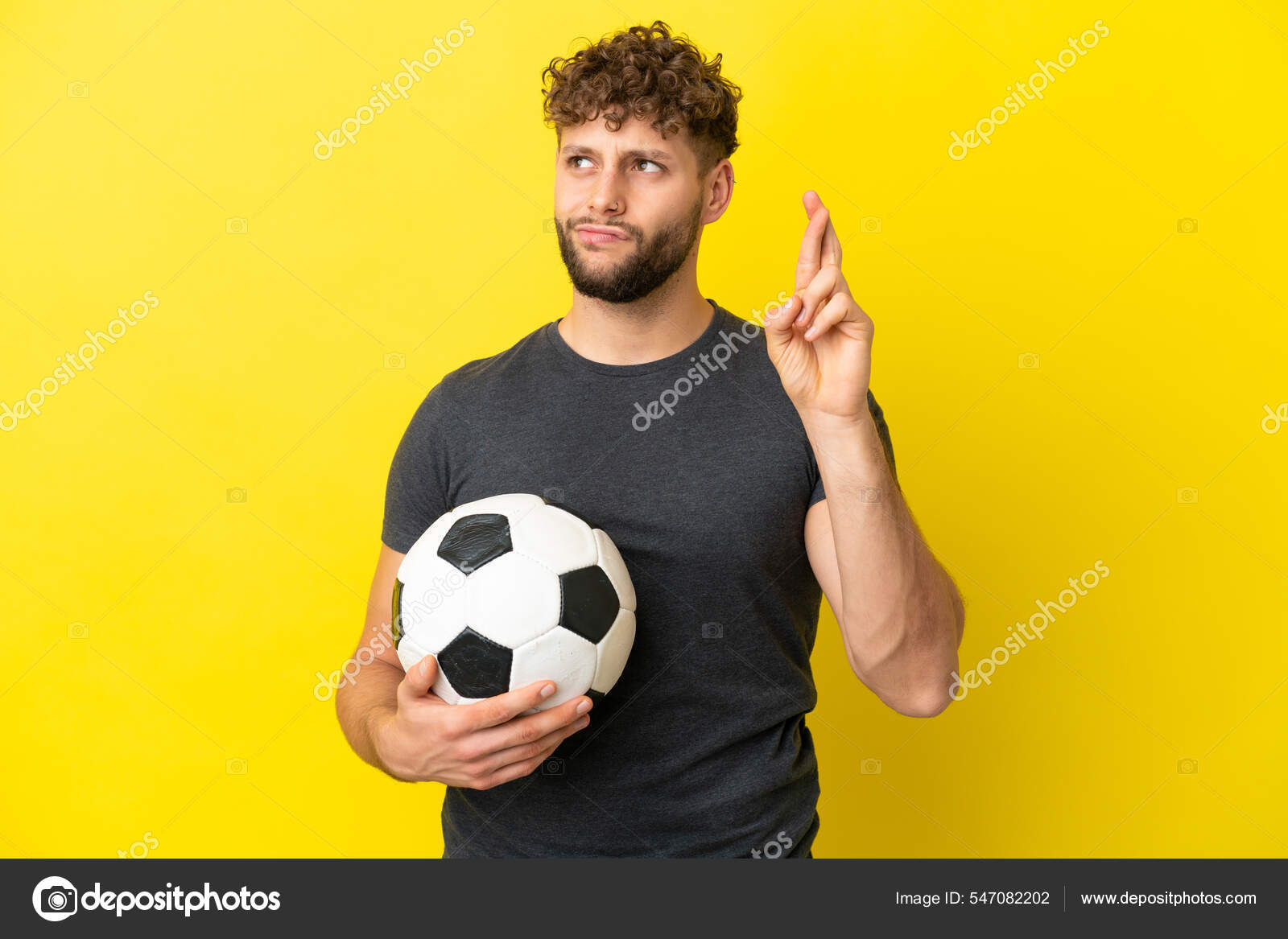 Jogador de futebol forte com bola de futebol e sorrindo em fundo branco  isolado